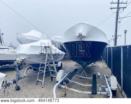 Boat On Trailers Shrink Wrapped With White Covers For Their Protection Over The Winter.