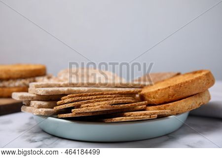 Rye Crispbreads, Rice Cakes And Rusks On White Marble Table, Space For Text
