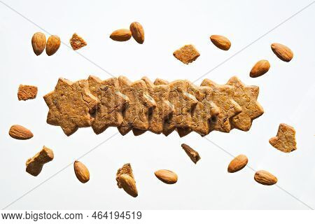 Levitation Of Star Cookies On Off White Background. Row Of Star Shaped Cinnamon Cookies, Almond Nuts