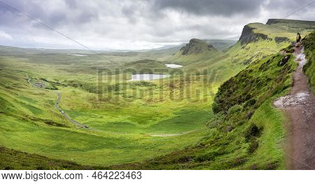 Hill Walkers Overlook The Quiraing And Winding Narrow Road,from A Mountainside Trail.