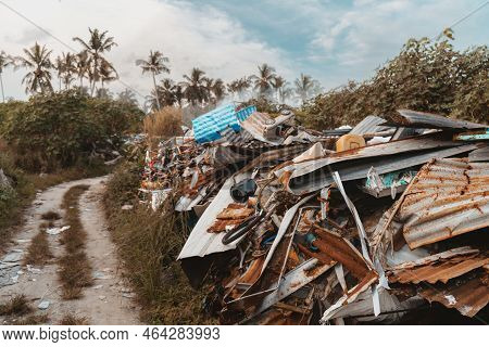 A Wide-angle Shot Of An Illegal Garbage Dump In The Jungle; A Scrap-heap With Rusty Trash Pieces Nex