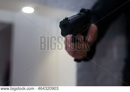Male Hand Holding A Gun On Black Background . A Gun In A Mans Hand. Defense Or Attack Murderer Or Ar