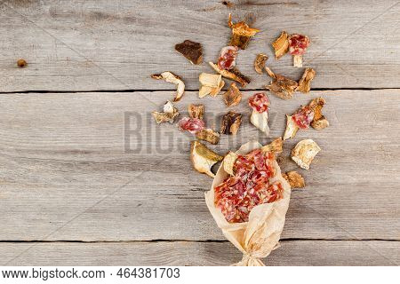 Dried Meat Jerky Appetizer With White Mushroms Scattered On Wooden Background. Snack For Beer