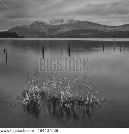 Black And White Stunning Landscape Image Of Loch Lomond And Snowcapped Mountain Range In Distance Vi