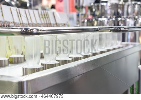 Row Glass Bottle Arrange On Automatic Bottle Washer And Sanitizing Machine In Beverage Industrial