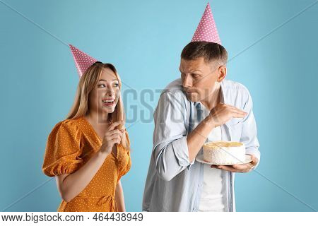 Greedy Man Hiding Birthday Cake From Woman On Turquoise Background