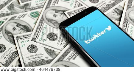 Twitter Logo On Smartphone Screen On Background Of Dollars. Twitter Is A Microblogging And Social Ne