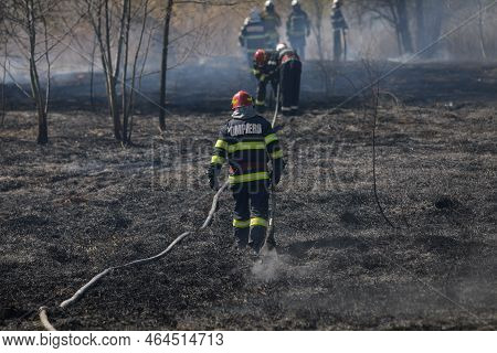 Bucharest, Romania - April 5, 2022: Firefighters Try To Extinguish A Wildfire Of Vegetation In The V