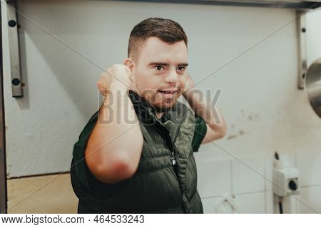 Man With Down Syndrome Working In Kitchen In Zoo, Prepairing Food For Animals.concept Of Integration