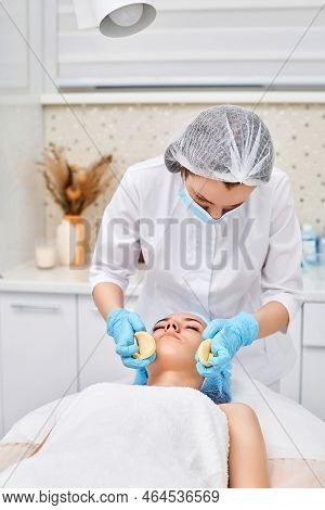 Beautician Cleanses Skin Of Beautiful Woman With A Sponge.