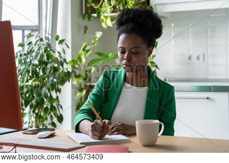 Self-sufficient African American Woman Working From Home Office Sits At Table With Personal Computer