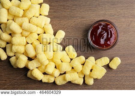 Bowl Of Jam And Delicious Crispy Corn Sticks On Wooden Table, Flat Lay