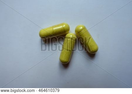 Top View Of Three Greenish Yellow Capsules Of Quercetin Dietary Supplement