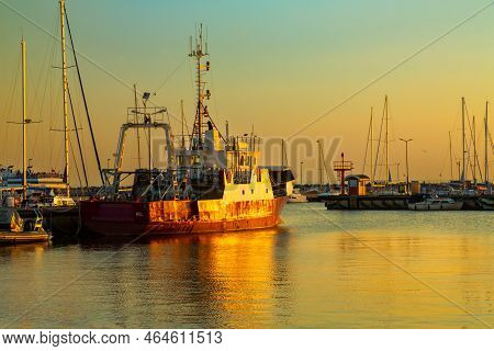 August, 27, 2022 A Fishing Boat In The Light Of The Setting Sun Moored In The Harbour In The Town Of