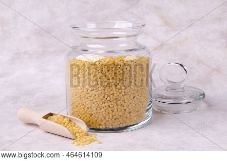 Traditional Dry Pearl Couscous In A Glass Jar On A Light Background. Selective Focus.