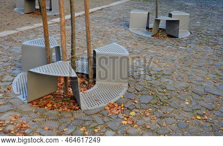 Bench Sitting With A Hole Around A Tree. Green Painted Metal Perforated Plate. Three Places Around T