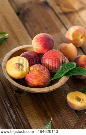Peaches With Leaves In A Wooden Bowl With Peach In Halves On Top. Flat Lay Composition With Ripe Jui