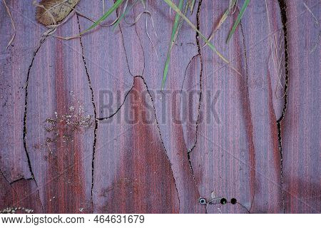 Brown Wooden Texture Of Slammed Plywood Board With Cracks Veneer On A Green Grass