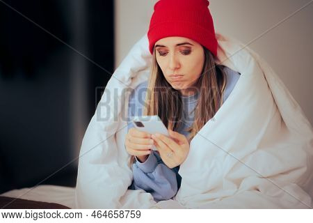 Stressed Woman Feeling Cold At Home Checking Her Phone