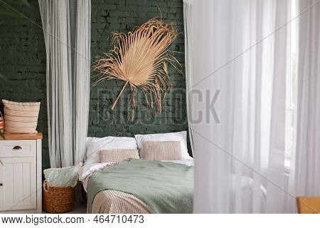 Modern Boho Interior Of Bedroom With Green Brick Wall, Bed, White Wooden Commode, Curtains, Housepla
