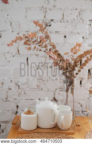 The Tea White Set On Wooden Tray On A White Brick Wall Background. Teapot, Creamer, Cup And Glass Va
