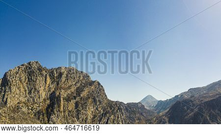 Drone Panoramic View Of Huge Mountain Cliffs High In The Blue Sky Over Oymapinar Dam Lake. The Lands