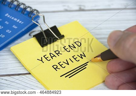 Year End Review Text On Yellow Notepad With December Calendar Background. Year End Review Concept.