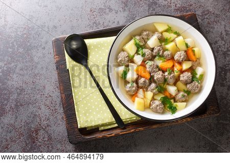 Delicious Soup With Root Vegetables And Beef Meatballs In A Clear Broth Close-up In A Plate On The T
