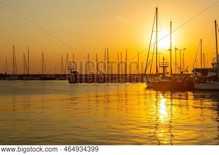 August, 27, 2022. Sailboats Moored In Hel Harbour.  Silhouettes Of Masts In The Light Of The Setting