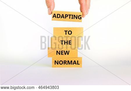 Adapting To The New Normal Symbol. Wooden Blocks With Words Adapting To The New Normal On Beautiful 
