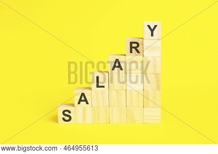Salary Word By Placing Wooden Cubic Blocks On Over Desk.