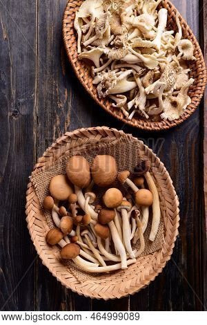 Fresh Edible Mushroom In Basket On Wooden Background, Table Top View