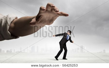 funny image of businessman trying to run away from hand