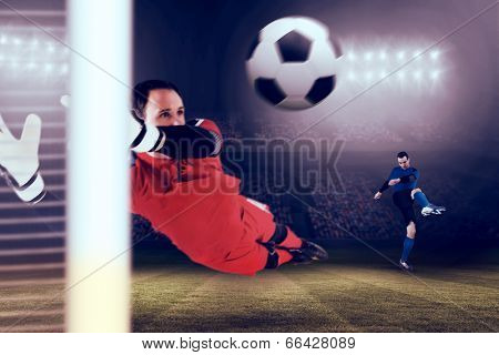 Fit goal keeper jumping up against large football stadium under blue sky