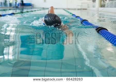 Fit swimmer doing the front stroke in the swimming pool at the leisure center