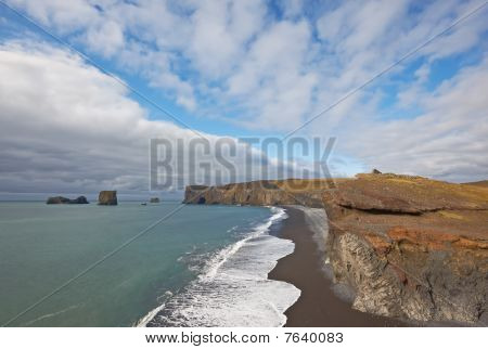 Black Sand Beach s Lundadrangur skalní oblouk v Dyrholaey, jih