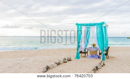 wedding arch and set up on beach, tropical outdoor wedding cabana on beach, wedding table for dinner at sunset