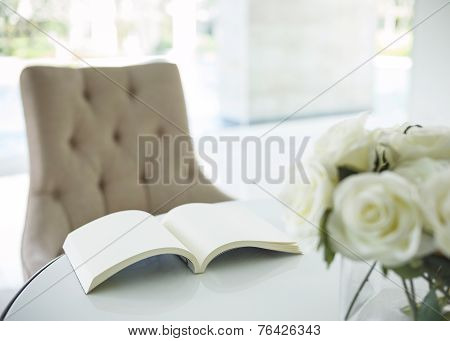 Book on Table with White Rose Flower in Living Room