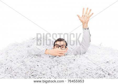 Studio shot of a man drowning in a pile of shredded paper isolated on white background