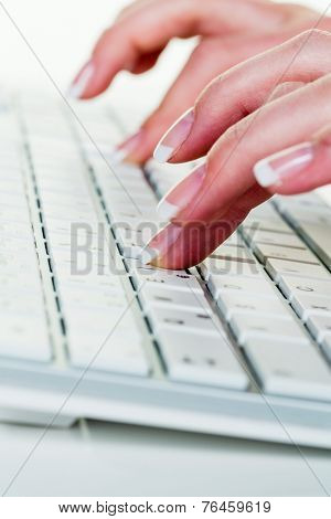 a woman in an office working on the keyboard of a computer