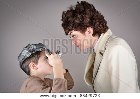 Son taking a picture of a smiling mother