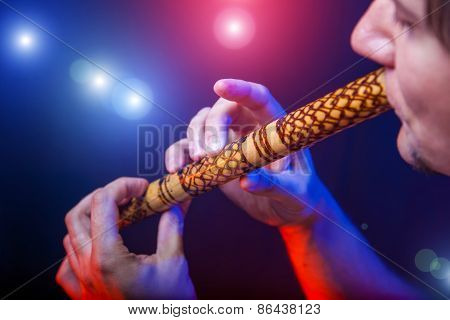 Folk musician in concert plays the melody on the Ethnic Flute