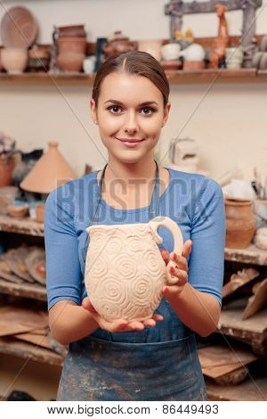 Girl holds a clay jar