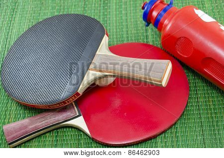 Two Vintage Table Tennis Rackets And A Water Bottle