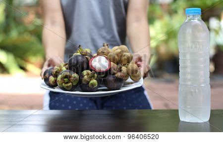 Lifestyle Woman holding plate of fruit in hands and watre