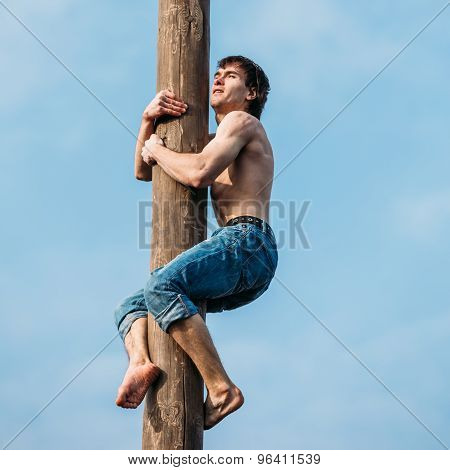 GOMEL, BELARUS - February 21, 2014: Young man climbs on a wooden