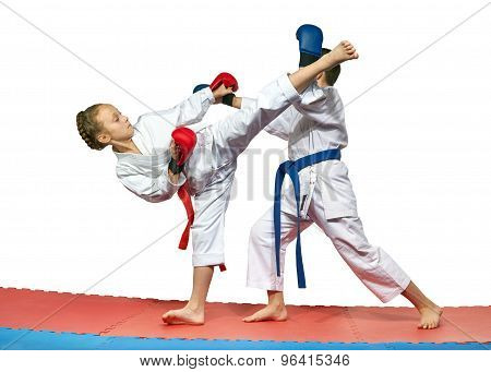 Children with red and blue belts are beating karate blows