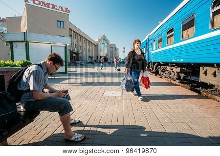 Unidentified people waiting on train on the station platform