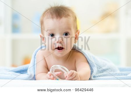 baby with teether wrapped blanket indoor