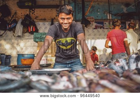 MUMBAI, INDIA - 08 JANUARY 2015: Worker on a fishmarket poses while waiting for customers. Post-processed with grain, texture and colour effect.